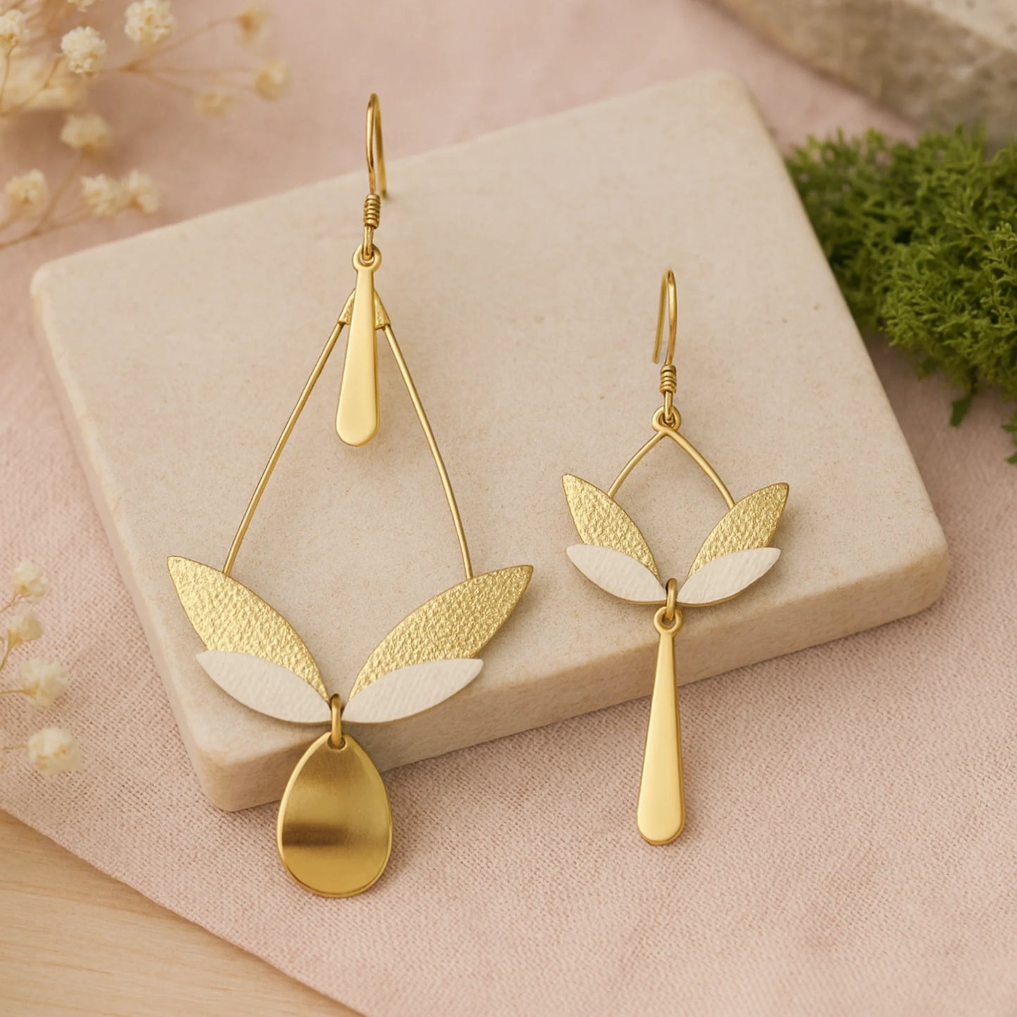 Boucles d’oreilles pendantes longues dépareillées, cuir texturé champagne clair et blanc, inspiration feuilles et ailes, bijou artisanal haut de gamme.